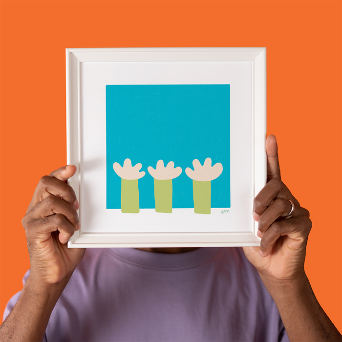 Man holding a white framed print with a pool getting filled with garden hoses.