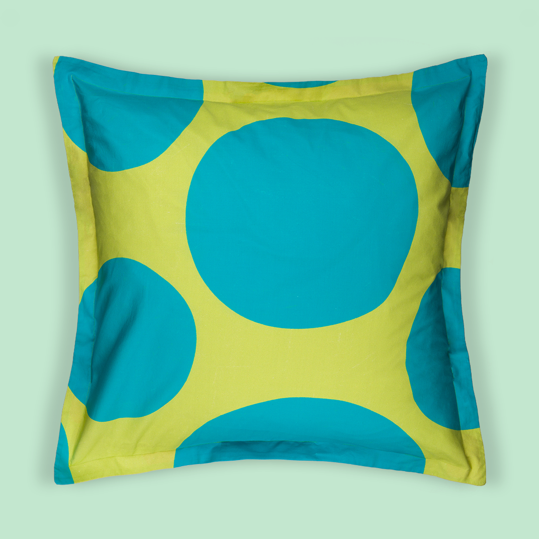 Front print of the pillow. The print is lime green on the background and big blue polka dots on top of the lime green.