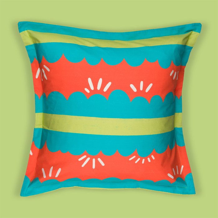 Photo of a pillow that has a red, green, and blue pattern. There are blue stripes that are ruffled with an inner green stripe. There is a red background that compliments the blue ruffle shapes.