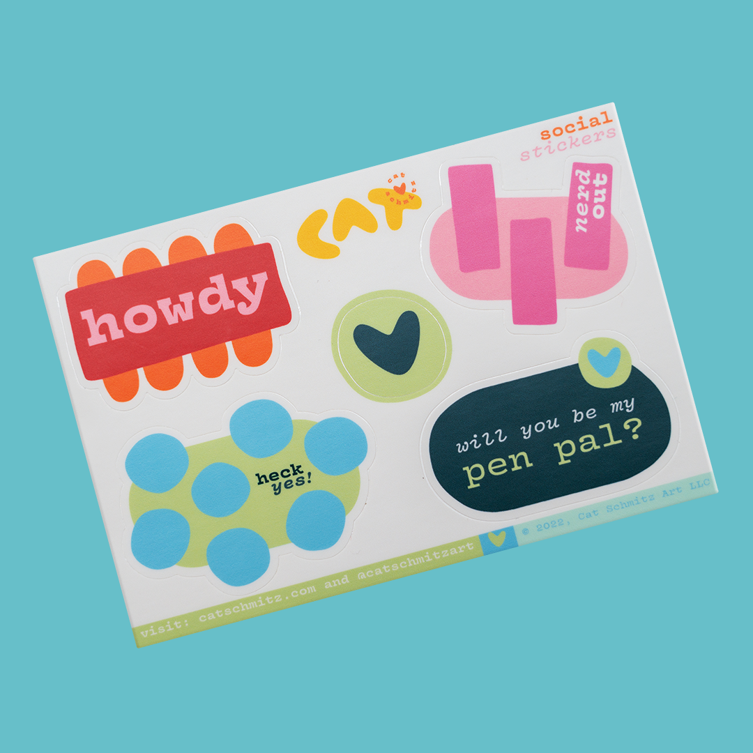 Top down view of a sticker sheet with five stickers. One sticker says howdy. Another sticker says nerd out, a third sticker says heck yes and the fourth sticker says will you be my pen pal? The last sticker is a circle with a heart and no text.