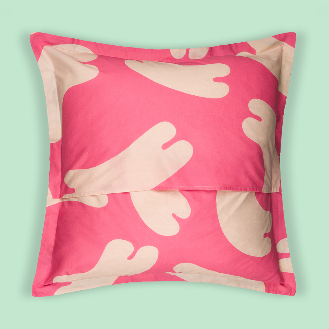Photo of the back of the pillow that showcases the pink printed fabric with white noodles floating all over the print.